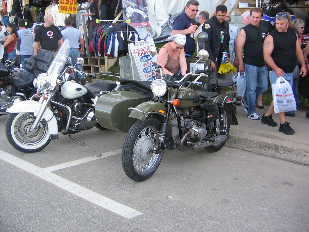 Real photograph of a green Ural motorcycle with a sidecar and additional wheel